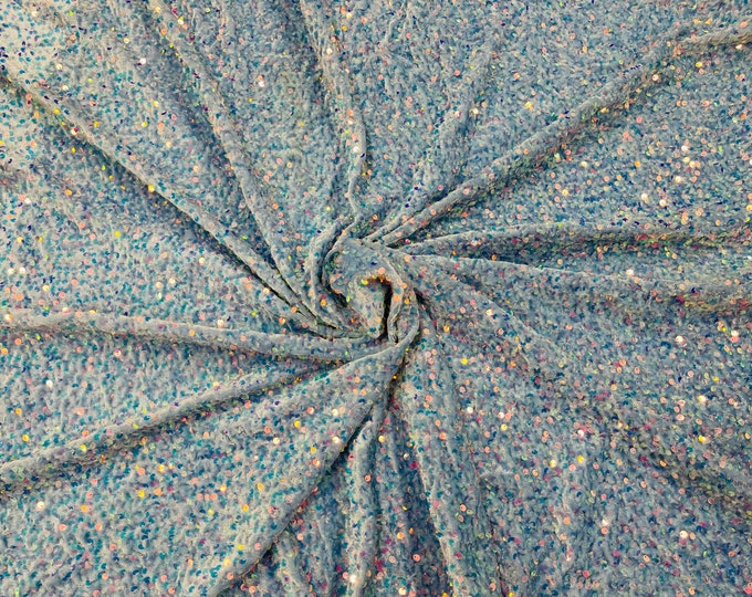 Clear Iridescent economic all over shiny sequins on a 2 way stretch light blue velvet, sold by the yard.