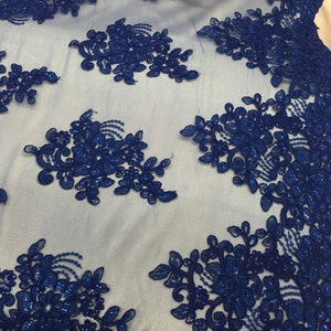 Puede incluir: Tela de encaje azul real con cuentas y dise&ntilde;o floral. El encaje est&aacute; sobre un fondo de malla transparente.