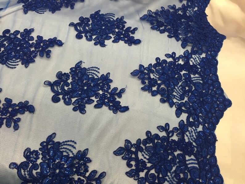Puede incluir: Tela de encaje azul real con cuentas y dise&ntilde;o floral. El encaje est&aacute; sobre un fondo de malla transparente.