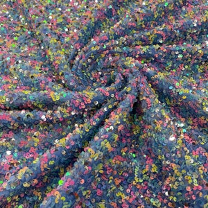 Multi color Confetti all over shiny sequins on  light blue stretch velvet , sold by the yard.