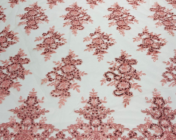 Pink corded flowers embroider with sequins on a mesh lace fabric-sold by the yard.