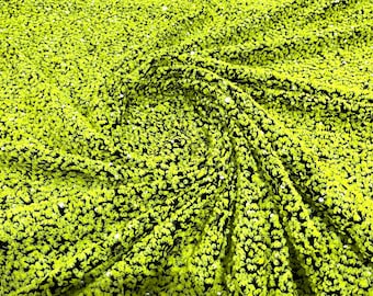 Neon green 5mm sequins on a black stretch velvet 2-way stretch, sold by the yard.