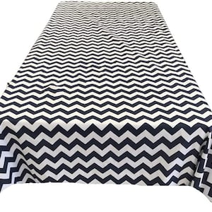 May include: A white and navy blue chevron patterned tablecloth. The tablecloth is rectangular and has a smooth, wrinkle-free surface.