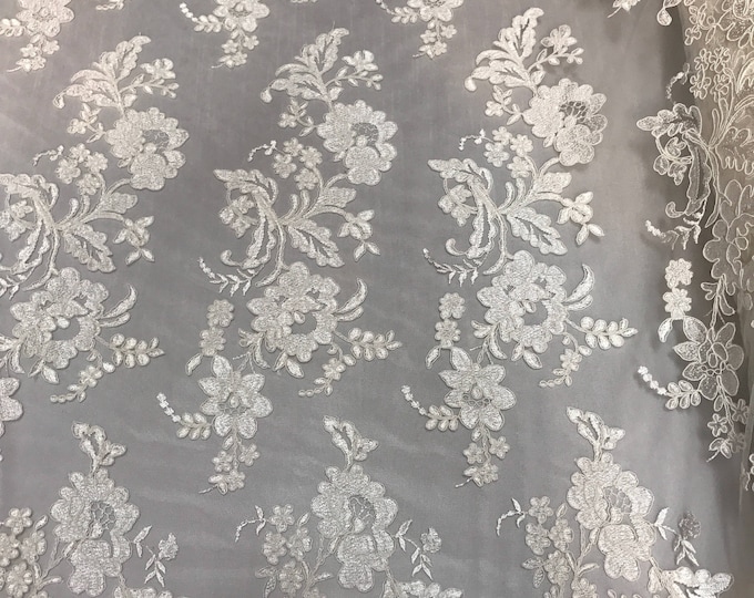 Ivory floral design embroider and corded on a mesh lace fabric-sold by the yard.