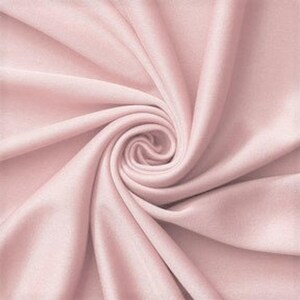 Könnte beinhalten: Ein einfarbiger, hellrosa Stoff mit einer glatten, matten Textur. Das Material ist in einem zentralen Spiralwirbel angeordnet, wodurch weiche, fließende Falten und tiefe Schatten entstehen, die vom Mittelpunkt der Stoffkomposition ausgehen.