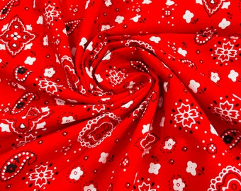 Könnte beinhalten: Roter Stoff mit einem weißen Paisley-Muster. Der Stoff ist gefaltet und zeigt das sich wiederholende Muster.
