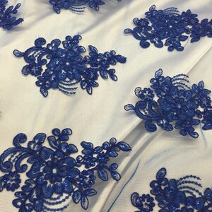 Puede incluir: Tela de encaje floral azul real con lentejuelas. El encaje presenta un delicado dise&ntilde;o floral con peque&ntilde;as lentejuelas en todo.