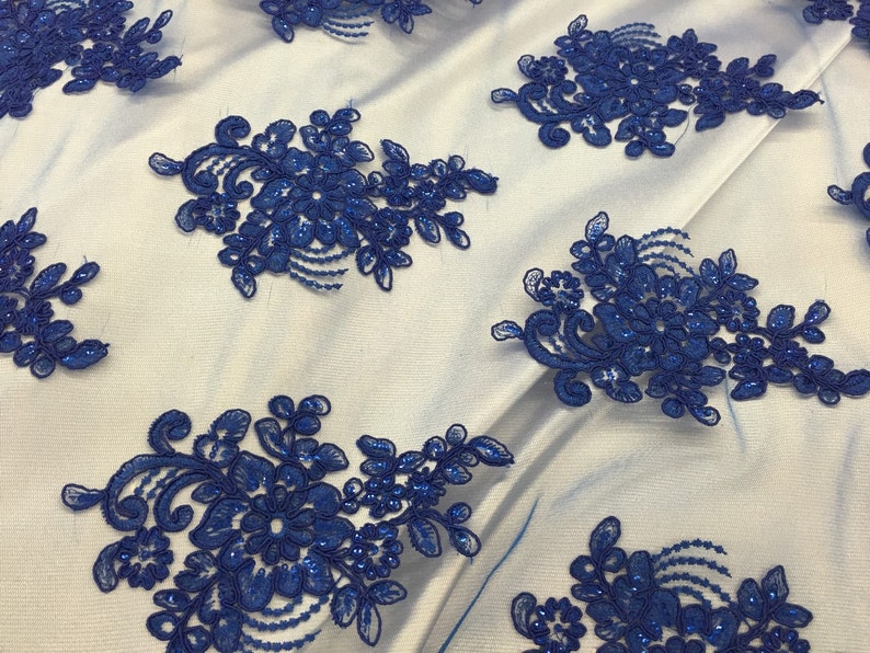 Puede incluir: Tela de encaje floral azul real con lentejuelas. El encaje presenta un delicado dise&ntilde;o floral con peque&ntilde;as lentejuelas en todo.