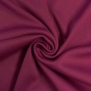 Könnte beinhalten: Nahaufnahme eines tief burgunderfarbenen Stoffes mit weicher, glatter Textur.