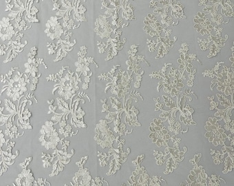 Ivory floral design embroider and corded on a mesh lace fabric-sold by the yard.