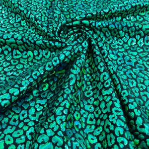 Green iridescent leopard  print on a black stretch nylon spandex tricot/milliskin -sold by the yard.