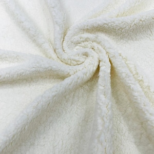 May include: A soft, off-white sherpa fleece fabric with a thick, textured, and curly pile surface. The material is gathered in the center, creating a swirling, radial pattern of folds and deep shadows that highlight the dense, fuzzy texture.