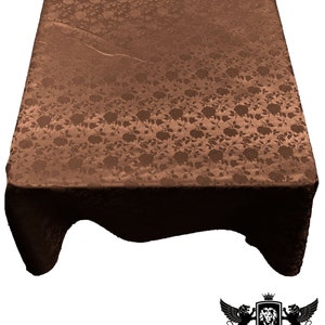 May include: A brown satin tablecloth with a floral pattern. The tablecloth is draped over a table and has a slight sheen.