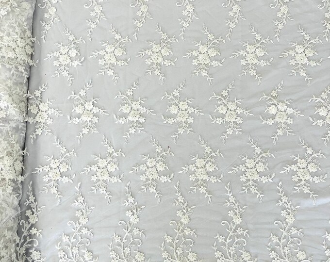 White flowers embroider with sequins and heavy beaded on a mesh lace fabric-sold by the yard.