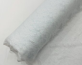 Tecido de renda elástica branca com estampa floral, 147 cm de largura, com elasticidade em 4 direções.