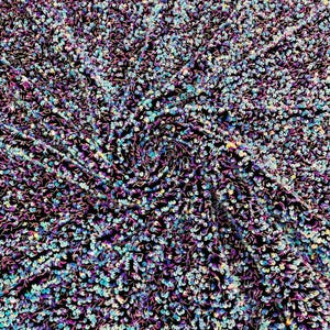 Velours stretch bleu aqua irisé / noir avec des paillettes argentées de luxe sur 5 mm, des paillettes brillantes extensibles dans les 2 sens, vendues par mètre.