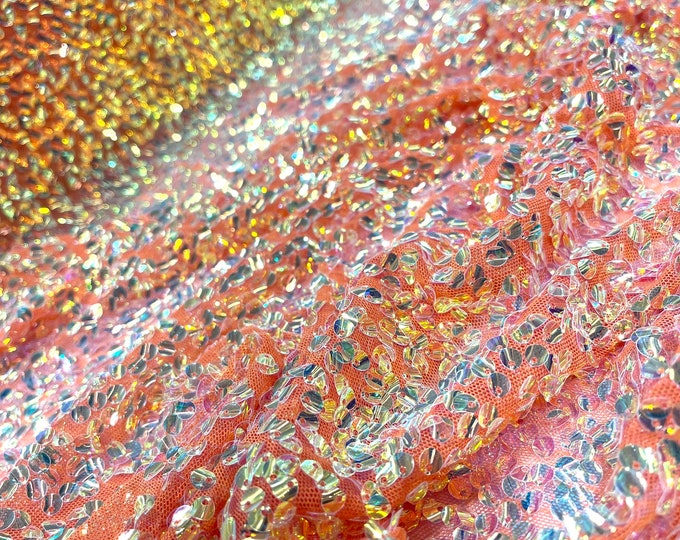 Aqua Clear iridescent mini round paillette sequins embroidered on a orange stretch mesh, sold by the yard.