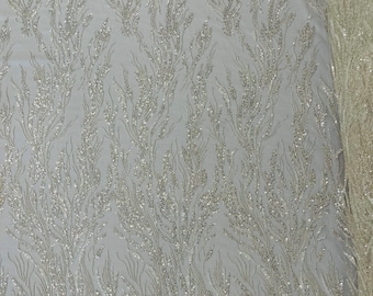 Off white/Clear Fancy Design Embroider and heavy beading on a mesh lace-sold by the yard.