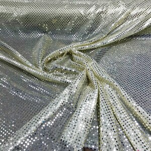 May include: A close-up of a gold fabric with silver sequins in a polka dot pattern.