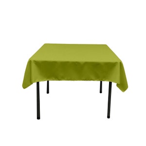 May include: A square green tablecloth with black metal legs. The tablecloth is draped over the table and the legs are visible.