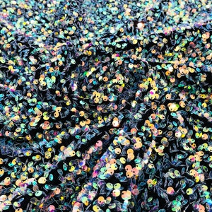 Clear iridescent 5mm sequins on a black stretch velvet 2-way stretch, sold by the yard.