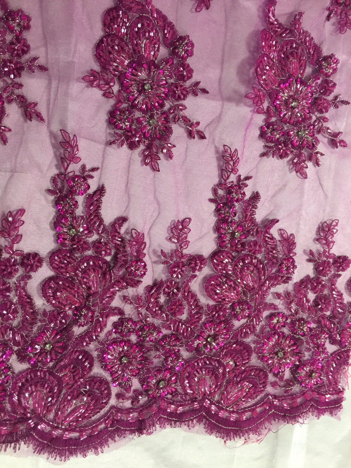 Magenta flowers embroider and heavy beaded on a mesh lace fabric