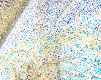 Aqua Clear iridescent mini round paillette sequins embroidered on a nude stretch mesh, sold by the yard.