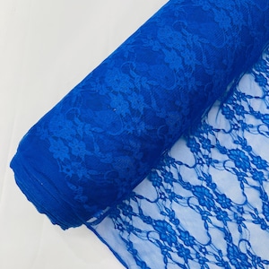 May include: A roll of vibrant royal blue lace fabric featuring a delicate, repeating floral pattern. The material is semi-sheer with an intricate, open-work design that showcases the detailed petal and leaf motifs throughout the entire length.