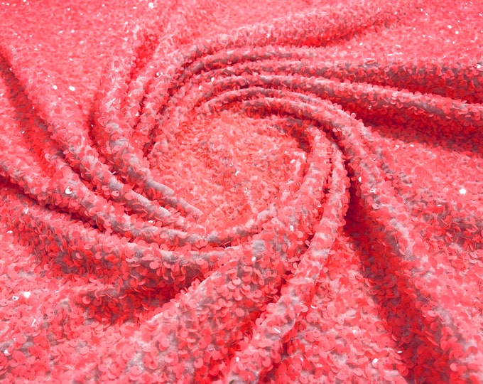 Neon coral 5mm sequins on a light pink stretch velvet 2-way stretch, sold by the yard.