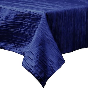 Peut inclure: Une nappe carrée de couleur bleu foncé, froissée. La nappe est faite d'un tissu doux et texturé.