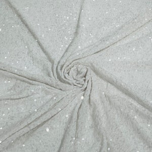 Clear 5mm sequins on a white stretch velvet 2-way stretch, sold by the yard.