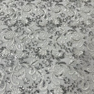 White/silver metallic corded embroider flowers with sequins on a mesh lace fabric-prom-sold by the yard.