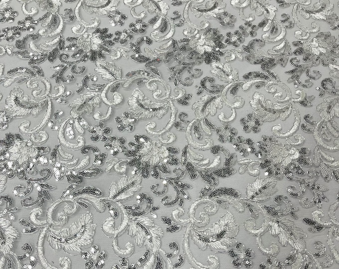 White/silver metallic corded embroider flowers with sequins on a mesh lace fabric-prom-sold by the yard.