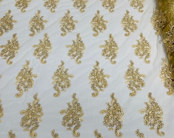 Gold Metallic floral design embroidery on a mesh lace with sequins and cord-sold by the yard.