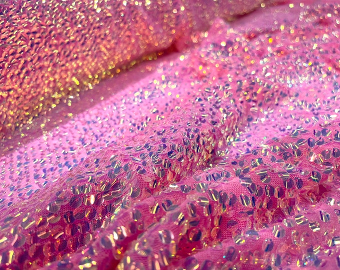 Aqua Clear iridescent mini round paillette sequins embroidered on a candy pink stretch mesh, sold by the yard.