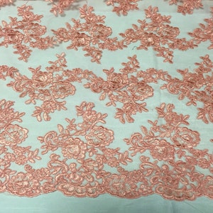 Coral modern roses embroider and corded on a mesh lace -yard