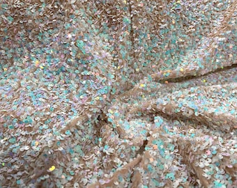 Aqua Iridescent sequins all over a blush stretch velvet , sold by the yard.