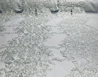 White roses floral design embroider on a white mesh lace fabric-sold by the yard.