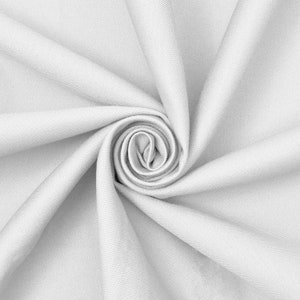 Puede incluir: Una tela de color gris claro sólido con un patrón de tejido de sarga diagonal visible. El textil está dispuesto en una espiral central apretada, creando pliegues profundos y radiantes y sombras que resaltan la textura y el color uniforme.