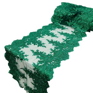 Op de afbeelding: Smaragdgroene kantstof met een bloemenpatroon. De kant is delicaat en ingewikkeld, met een gegolfde rand.