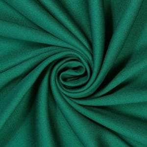 Könnte beinhalten: Ein einfarbiger, dunkel smaragdgrüner Stoff mit einer weichen, matten Textur. Das Material ist in einer zentralen Spirale angeordnet, wodurch tiefe, fließende Falten und Schatten entstehen, die vom Mittelpunkt aus über die Fläche strahlen.