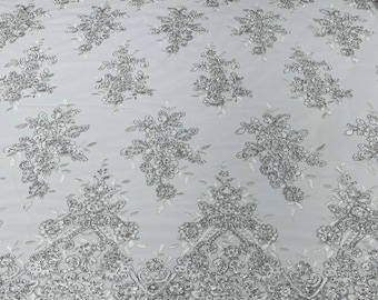 Metallic White flower lace corded and embroider with sequins on a mesh-Sold by the yard.