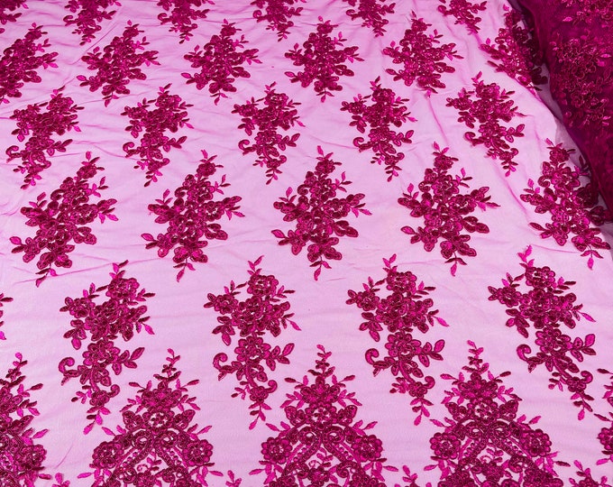 Fuchsia floral design embroidery on a mesh lace with sequins and cord-sold by the yard.