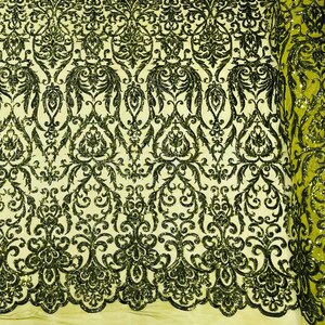 May include: A roll of lime green mesh fabric featuring an intricate, repeating damask pattern embroidered with dark green sequins. The design includes symmetrical floral and scrollwork motifs that cover the entire surface of the sheer material.
