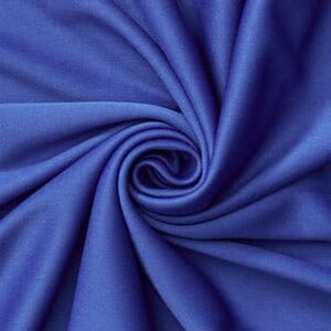 Könnte beinhalten: Ein einfarbiger, königsblauer Stoff mit glatter, matter Textur, der in einem zentralen Spiralwirbelmuster angeordnet ist. Das Material weist weiche, fließende Falten auf, die von der Mitte ausstrahlen und tiefe Schatten und Lichter erzeugen.