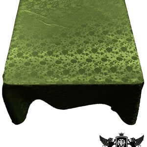 May include: A green tablecloth with a floral pattern. The tablecloth is made of a satin-like material and has a slight sheen.