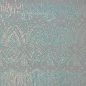 May include: Pale blue iridescent fabric with a geometric pattern of sequins. The fabric has a scalloped edge.