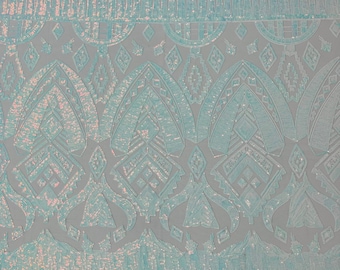Clear aqua iridescent geometric Aztec  design embroidery with sequins on a White 4 way stretch mesh fabric-sold by the yard.