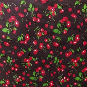 May include: Black fabric with a repeating pattern of red cherries with green stems and leaves.