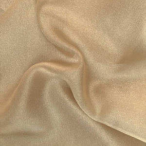 Tela de organza de cristal color champán, 100 % poliéster, suave, liviana, transparente, de 58/60" de ancho. Se vende cortada a medida.